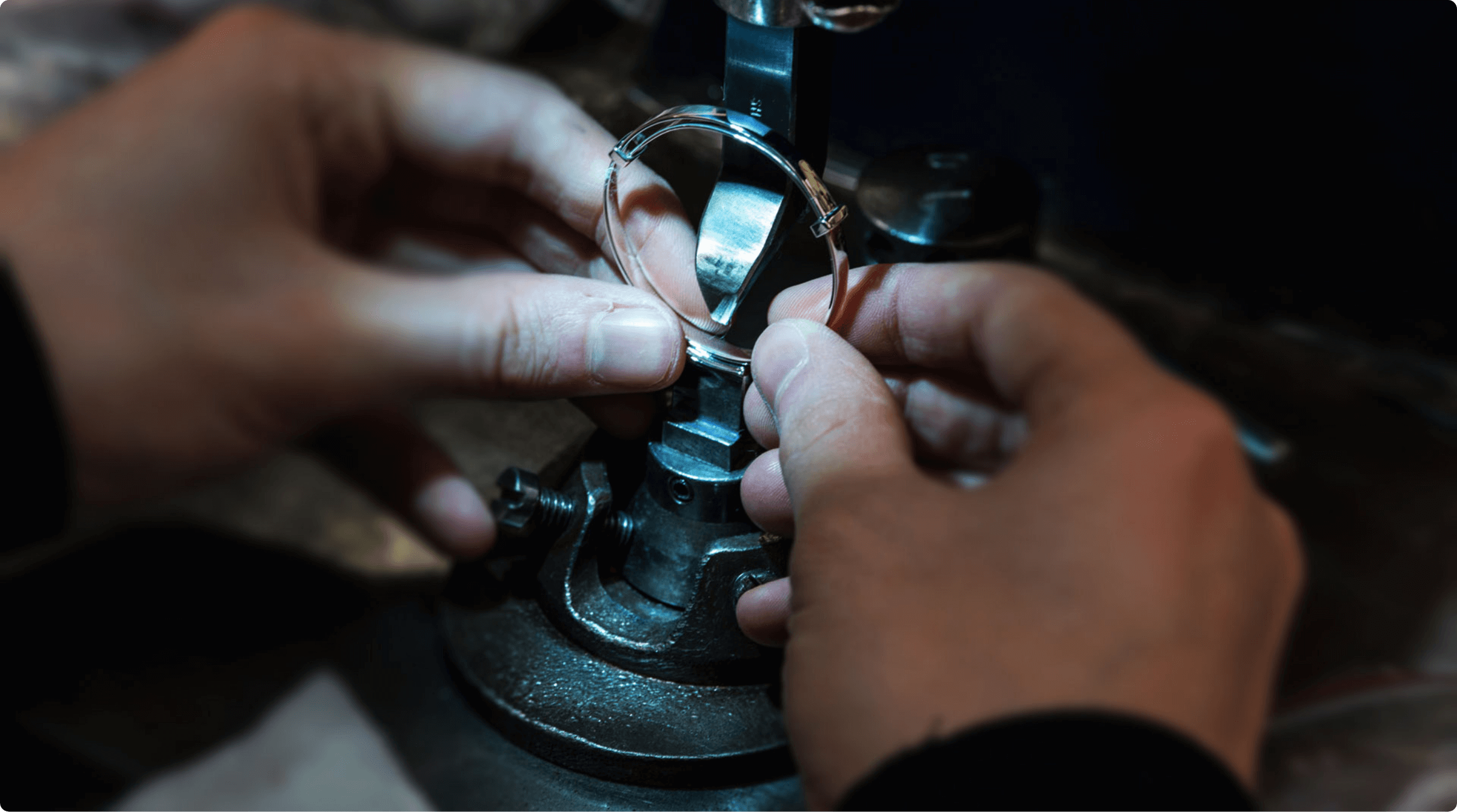 Image of ring in clamp being shaped by hand