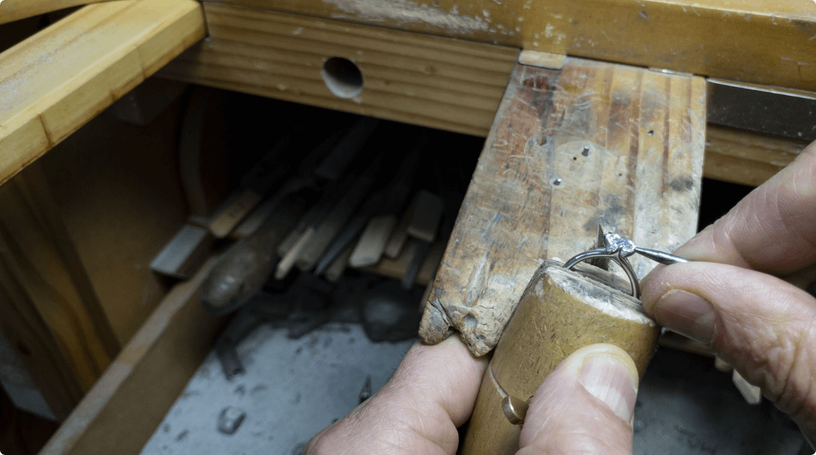 Image of ring being filed against a piece of wood